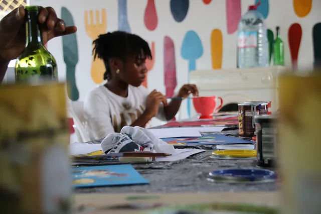 Une élève de L'Eldorado peint la fresque murale de l'école